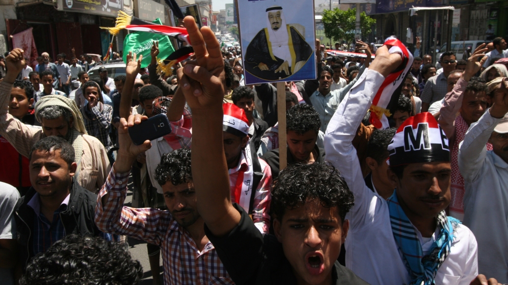 Yemenis hold a poster of the King of Saudi Arabia Salman as they chant slogans during a rally to show support for Saudi-led airstrikes against Houthis [AP]