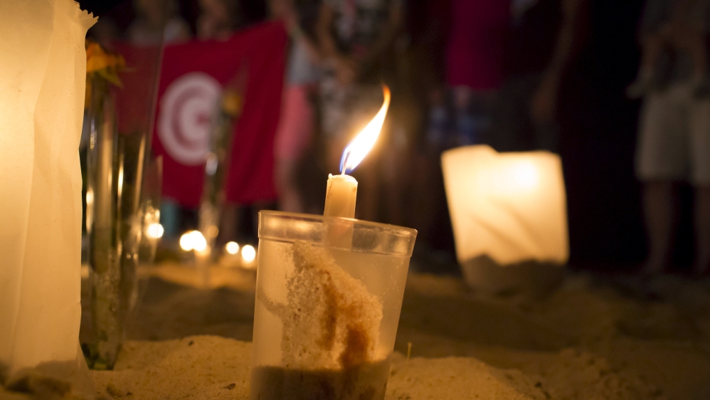 A lit candle is seen in the sand in front of the Imperial Marhaba Hotel, where a gunman carried out an attack, in Sousse, Tunisia [REUTERS]