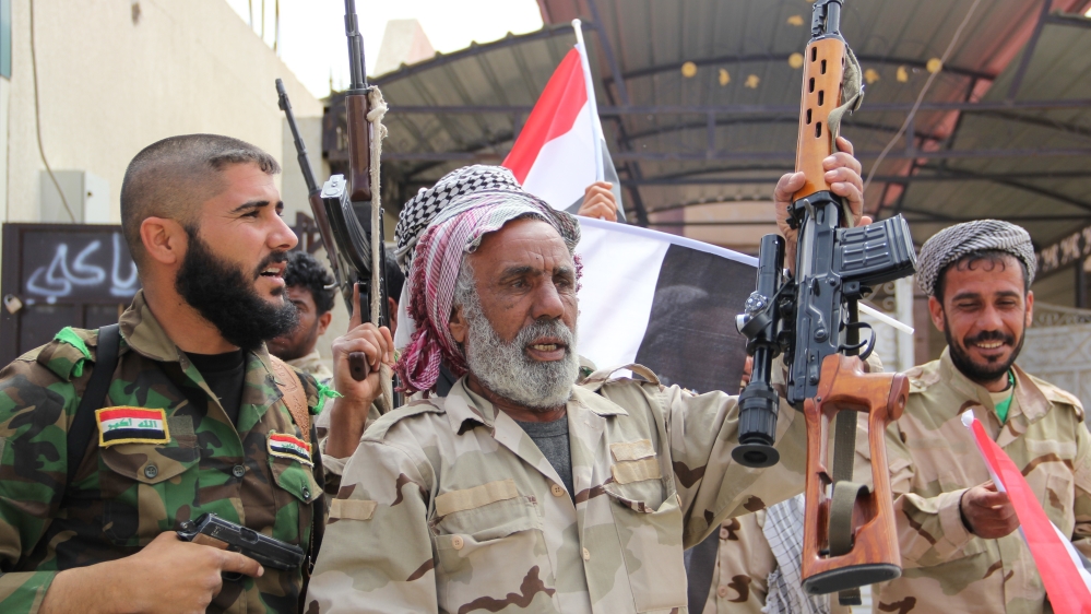 Iraqi forces, including soldiers, police officers, Shia militias and Sunni tribes, celebrate after regaining full control of Tikrit [Getty]