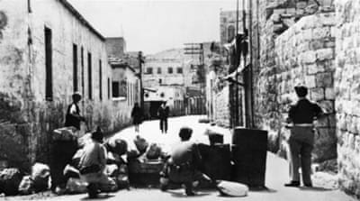 An Arab couple from Haifa finding their way blocked by a Haganah barricade on May 11, 1948 [AFP]