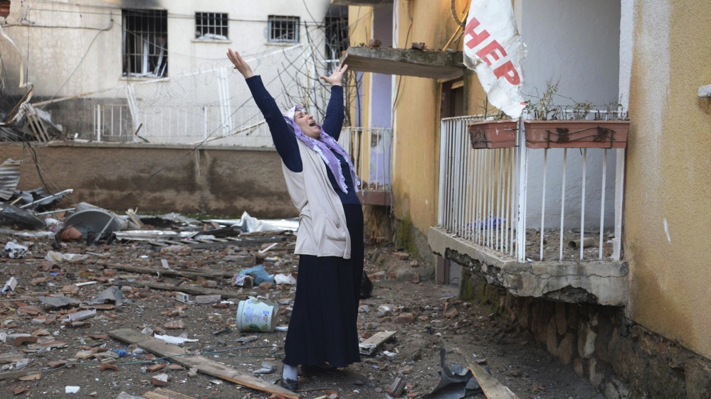 A woman cries in the compound of a destroyed police station in Cinar, Diyarbakir
