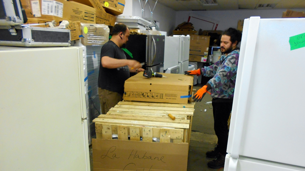 Cote's employees wrap electric bicycles to be shipped to Cuba [Andreanne Williams/Al Jazeera]