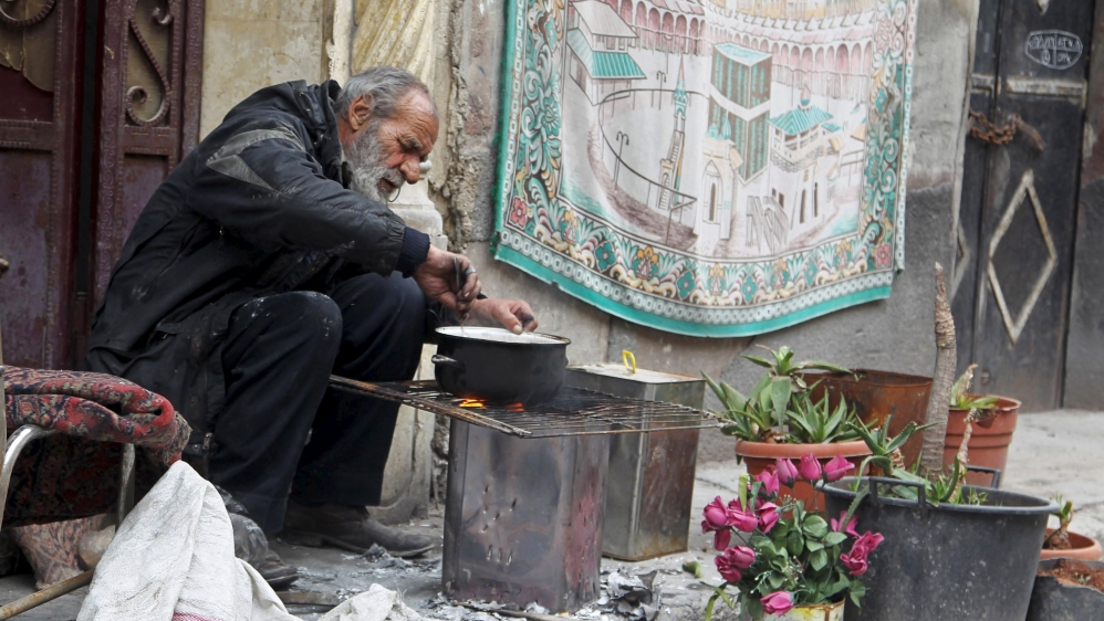 A man cooks a meal using firewood in Aleppo