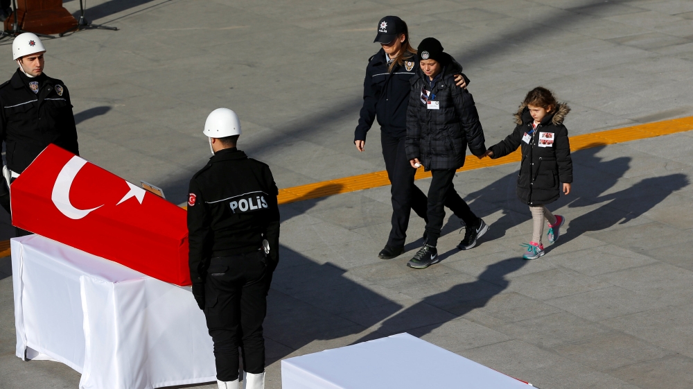 Children of a policeman who died in Saturday''s blasts, walk to their father''s coffin during a ceremony at the police headquarters in Istanbul