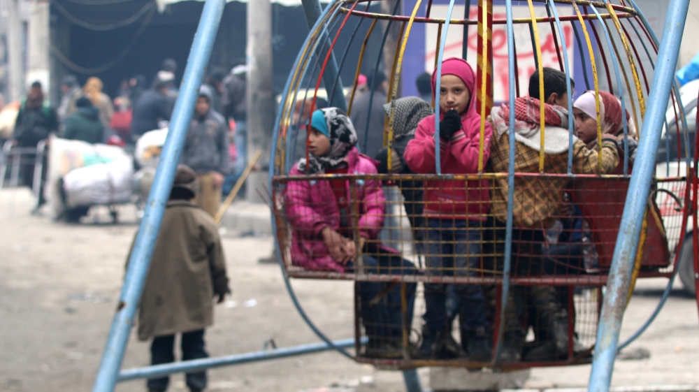 Children play while waiting to be evacuated with others from a rebel-held sector of eastern Aleppo