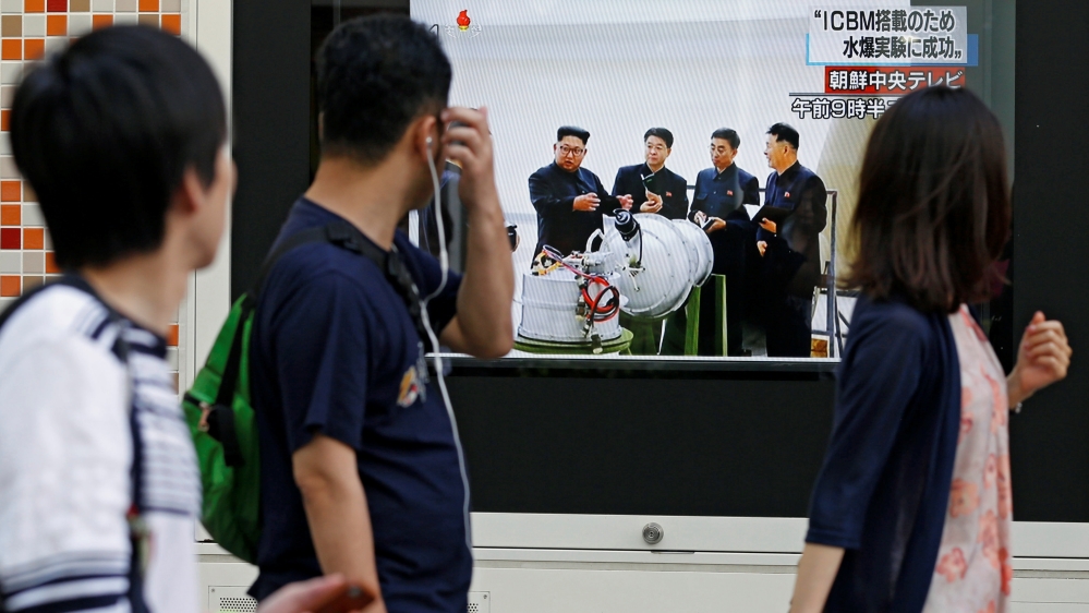 People walk past a monitor showing North Korea's leader Kim Jong-un in a news report about the nuclear test, in Tokyo [Toru Hanai/Reuters]