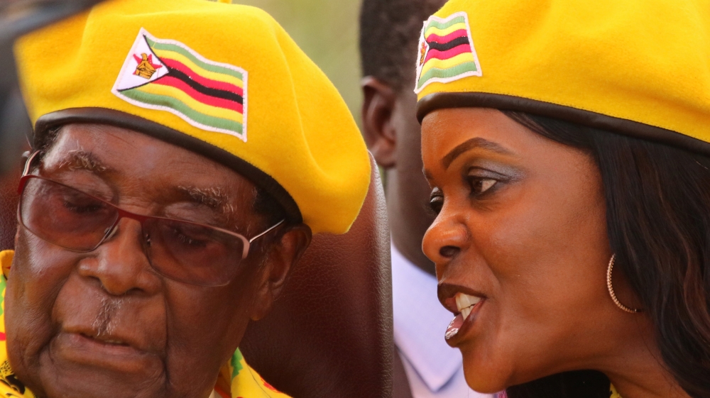 FILE PHOTO: President Robert Mugabe listens to his wife Grace Mugabe at a rally of his ruling ZANU(PF) party in Harare