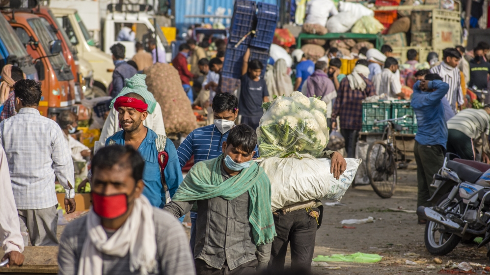 People walk in a crowded Mandi (market place) in New Delhi, as the nationwide lockdown continues