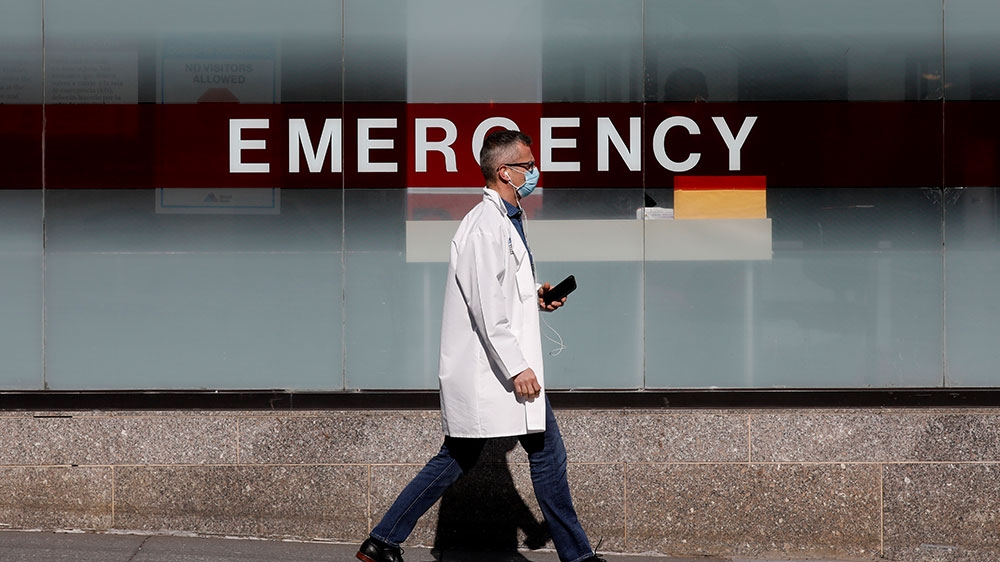 A doctor wears a protective mask as he walks outside Mount Sinai Hospital in Manhattan during the outbreak of COVID-19 in New York City