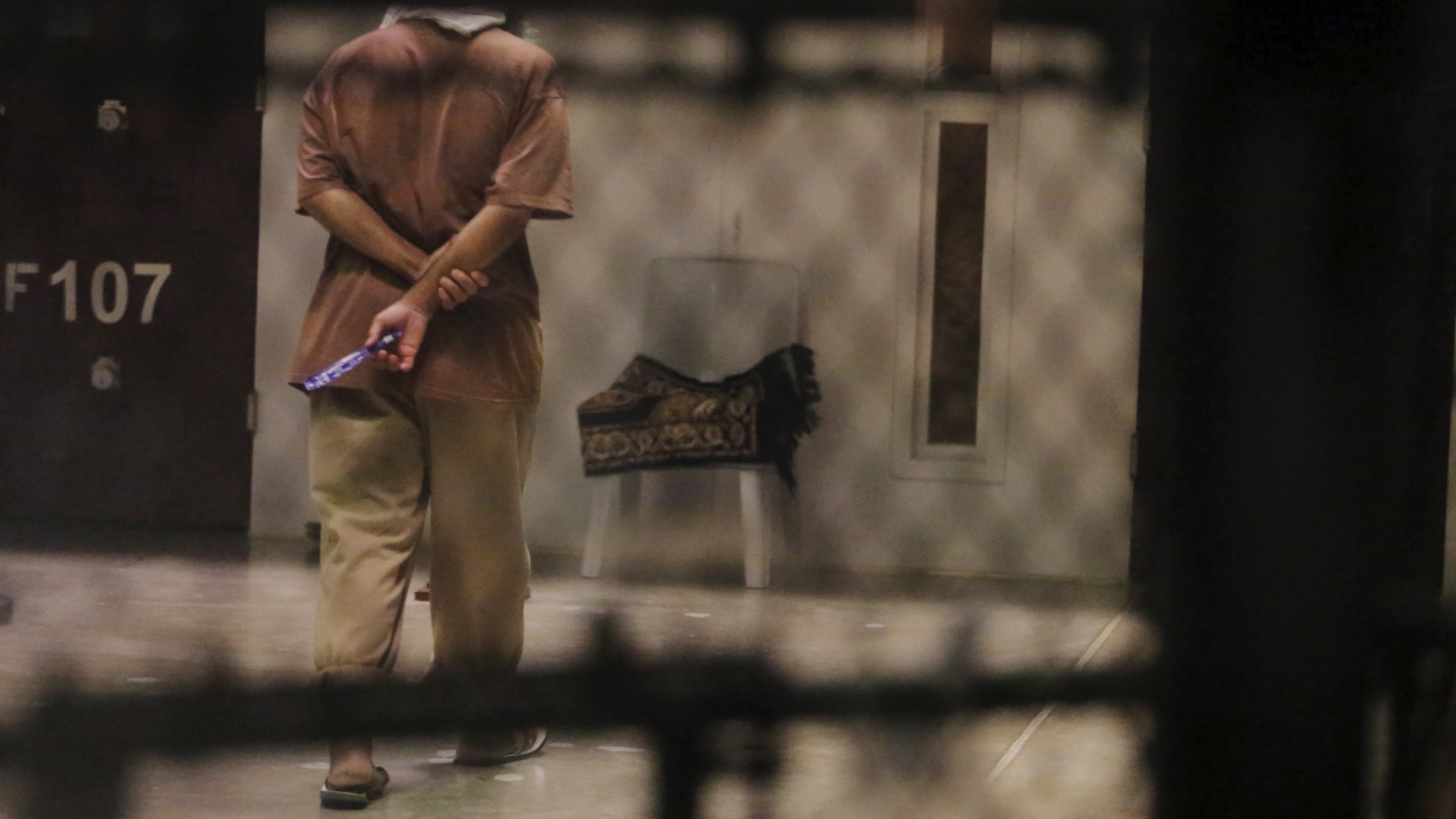 A detainee paces around a cell block in Guantanamo Bay