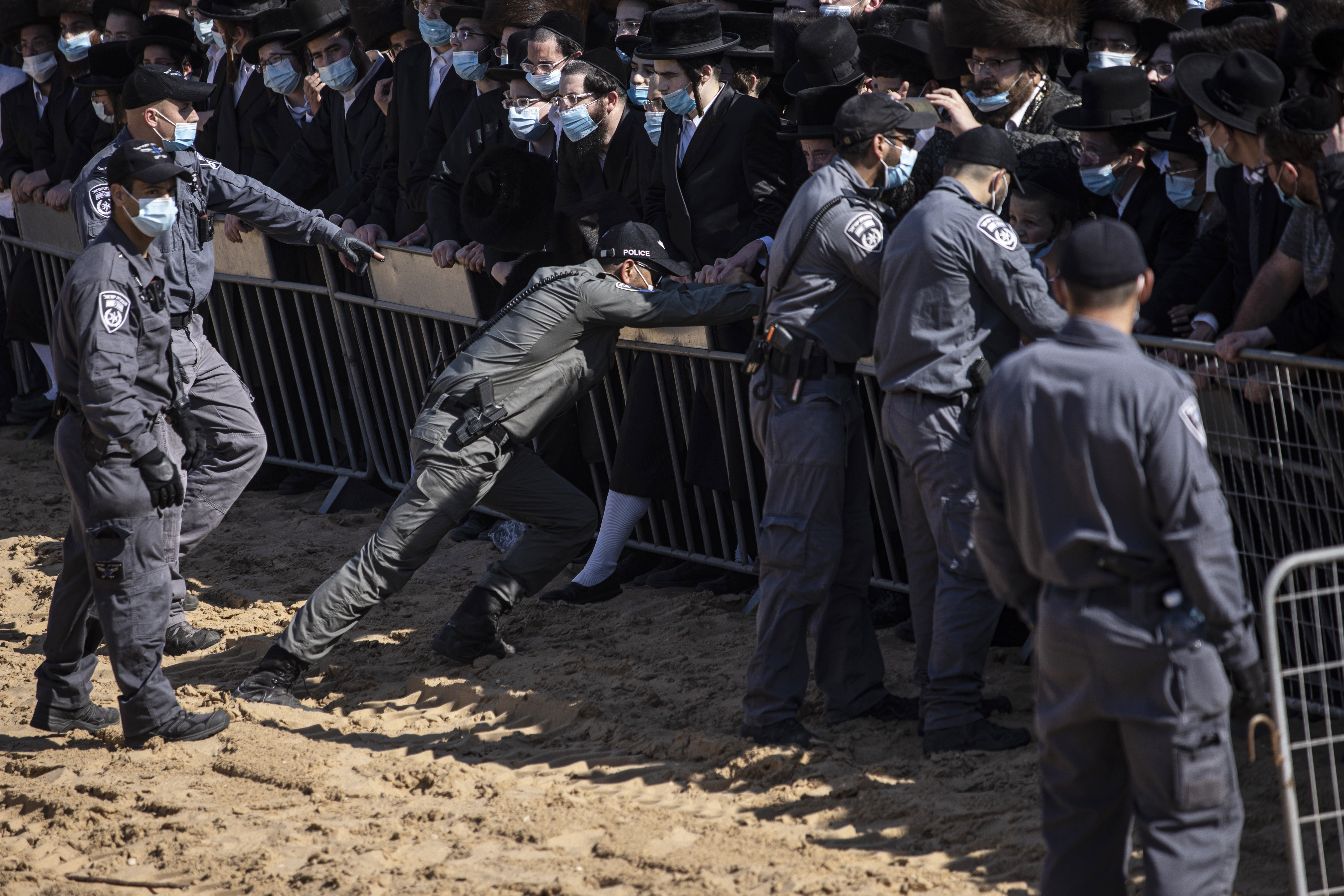 Israeli police try to control a crowd of mourners during the funeral of Rabbi Mordechai Leifer, the latest in a string of clashes between security forces and ultra-Orthodox Jews violating a national coronavirus lockdown order, in the port city of Ashdod, Israel on October 5, 2020 [AP/Tsafrir Abayov]