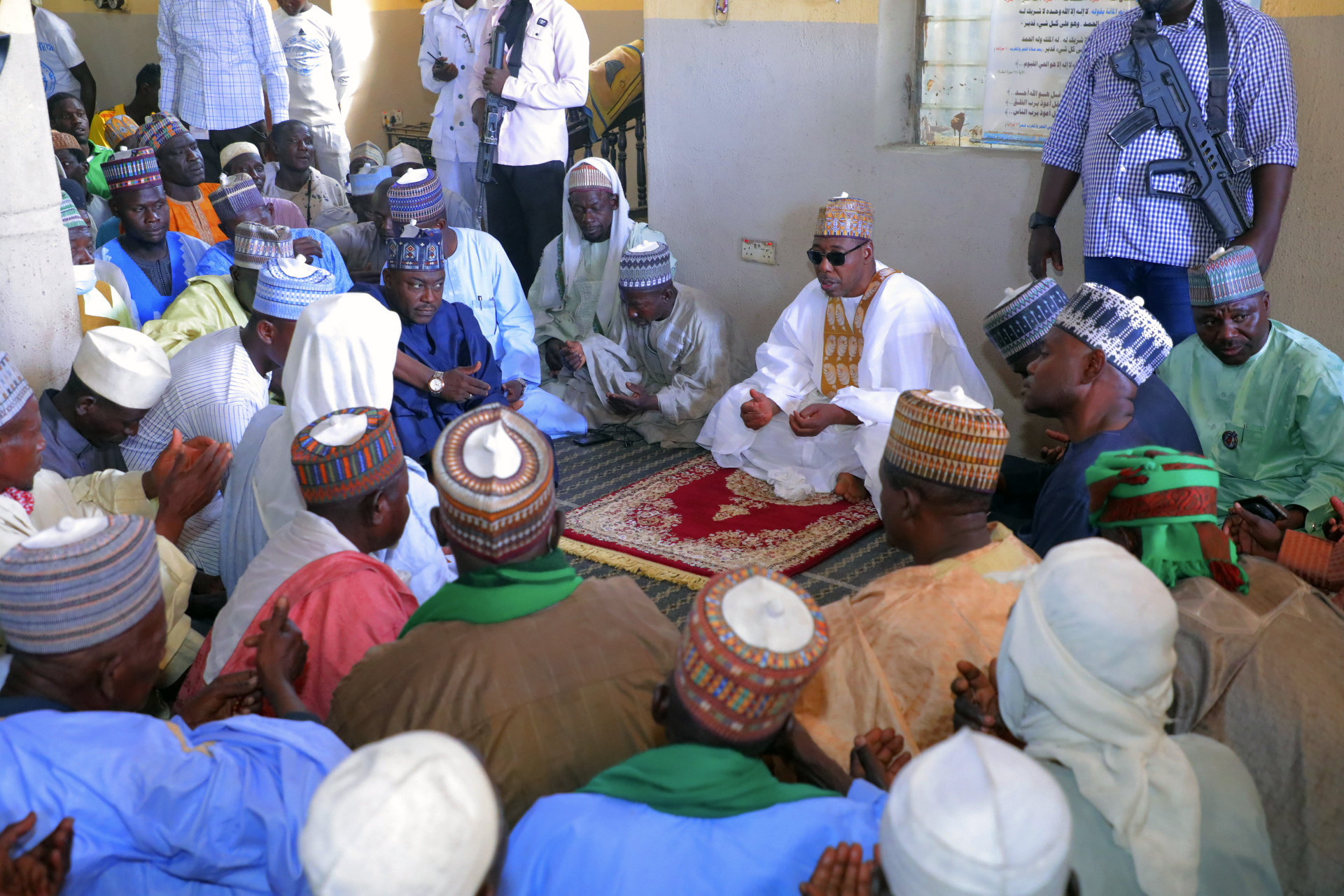 Borno State Governor Babagana Umara Zulum (centre) prays during the funeral in Zabarmari village for those killed in Saturday’s attack [Jossy Ola/AP Photo]