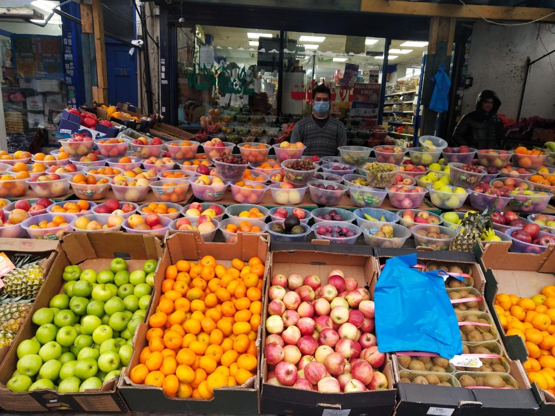 Zar Nabi, 30, from Afghanistan, tends his fruit and vegetable stall in the Alum Rock neighbourhood of Birmingham, UK [Anam Hussain/Al Jazeera]