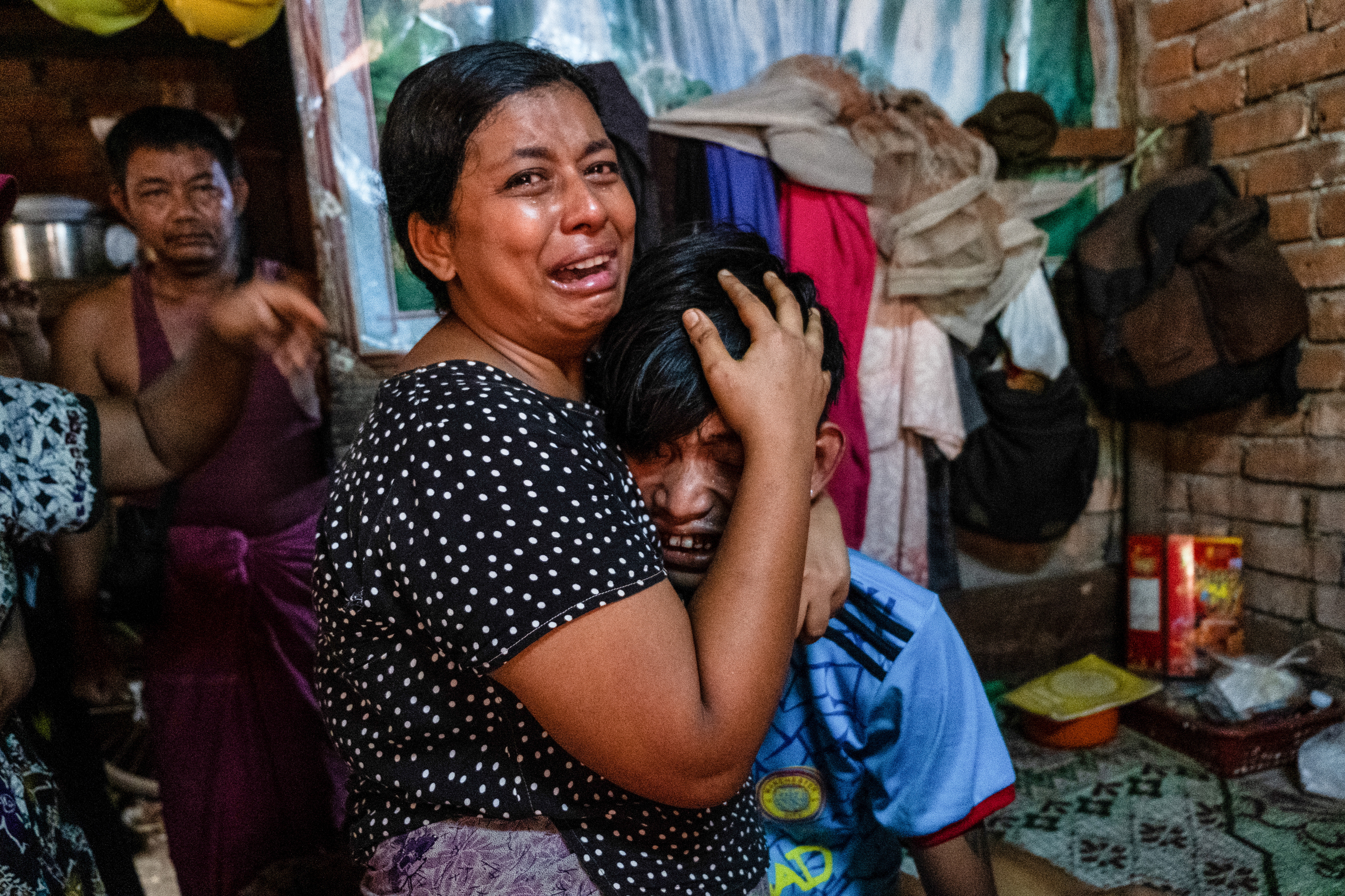 Family members including a young boy mourn a man who was shot dead during an operation against anti-coup protesters in Yangon, Myanmar, March 27, 2021 [Stringer/Reuters]