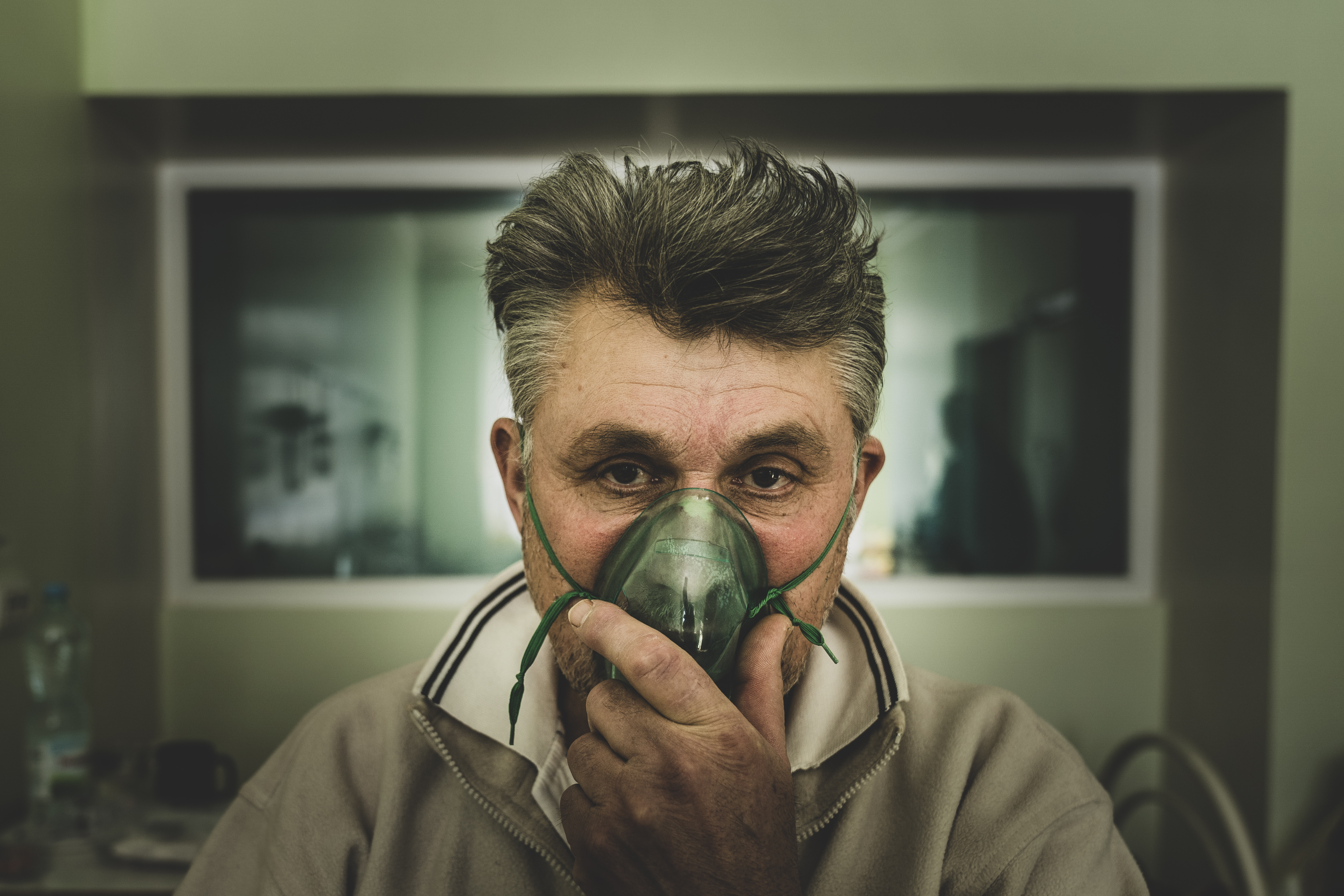 A coronavirus patient breathes in oxygen at a hospital's infectious disease ward in Sievierodonetsk in eastern Ukraine [Evgeniy Maloletka/Al Jazeera]