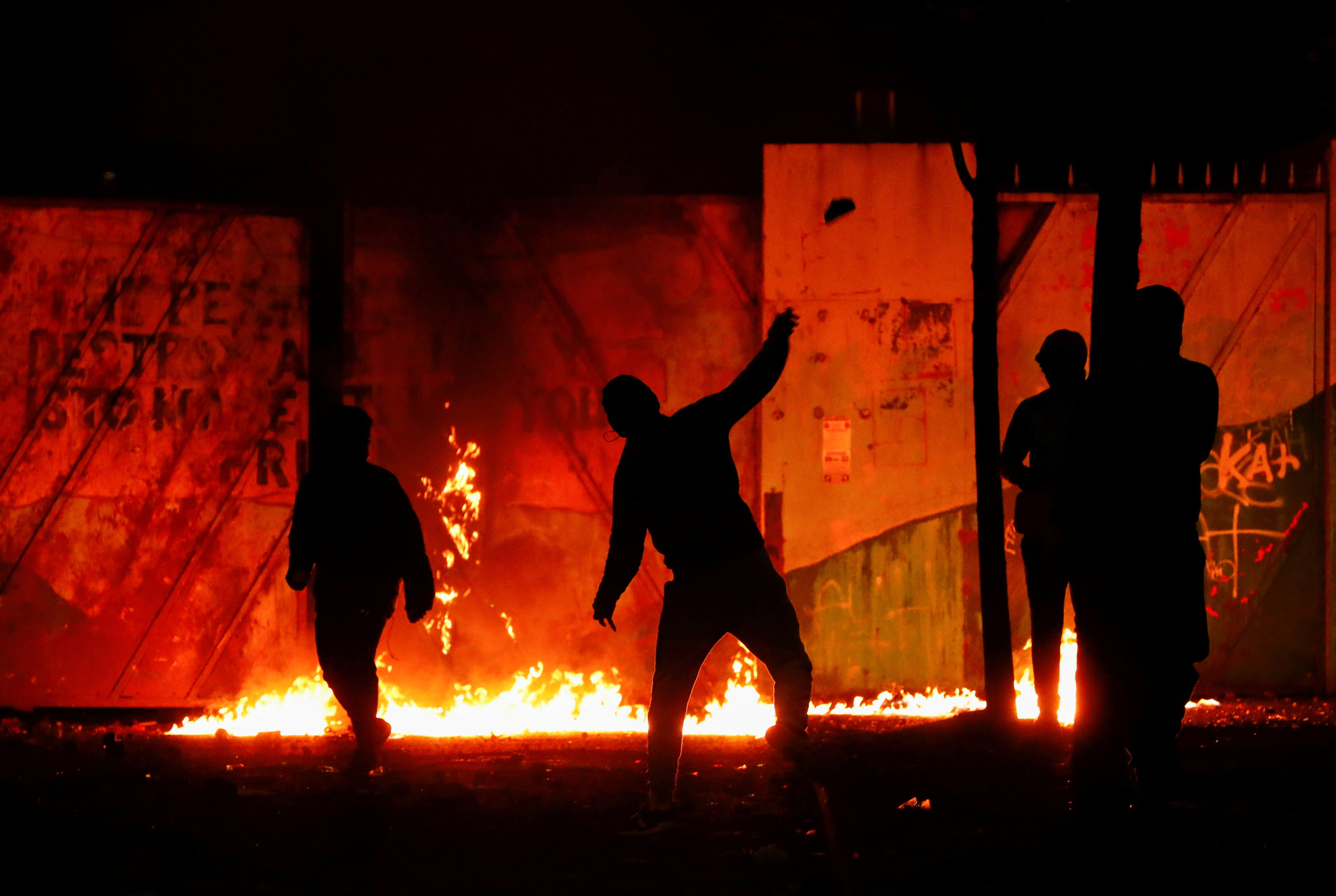 Protesters are seen at the 'peace wall' gate into Lanark Way as protests continue in Belfast, Northern Ireland on April 7, 2021 [Reuters/Jason Cairnduff]