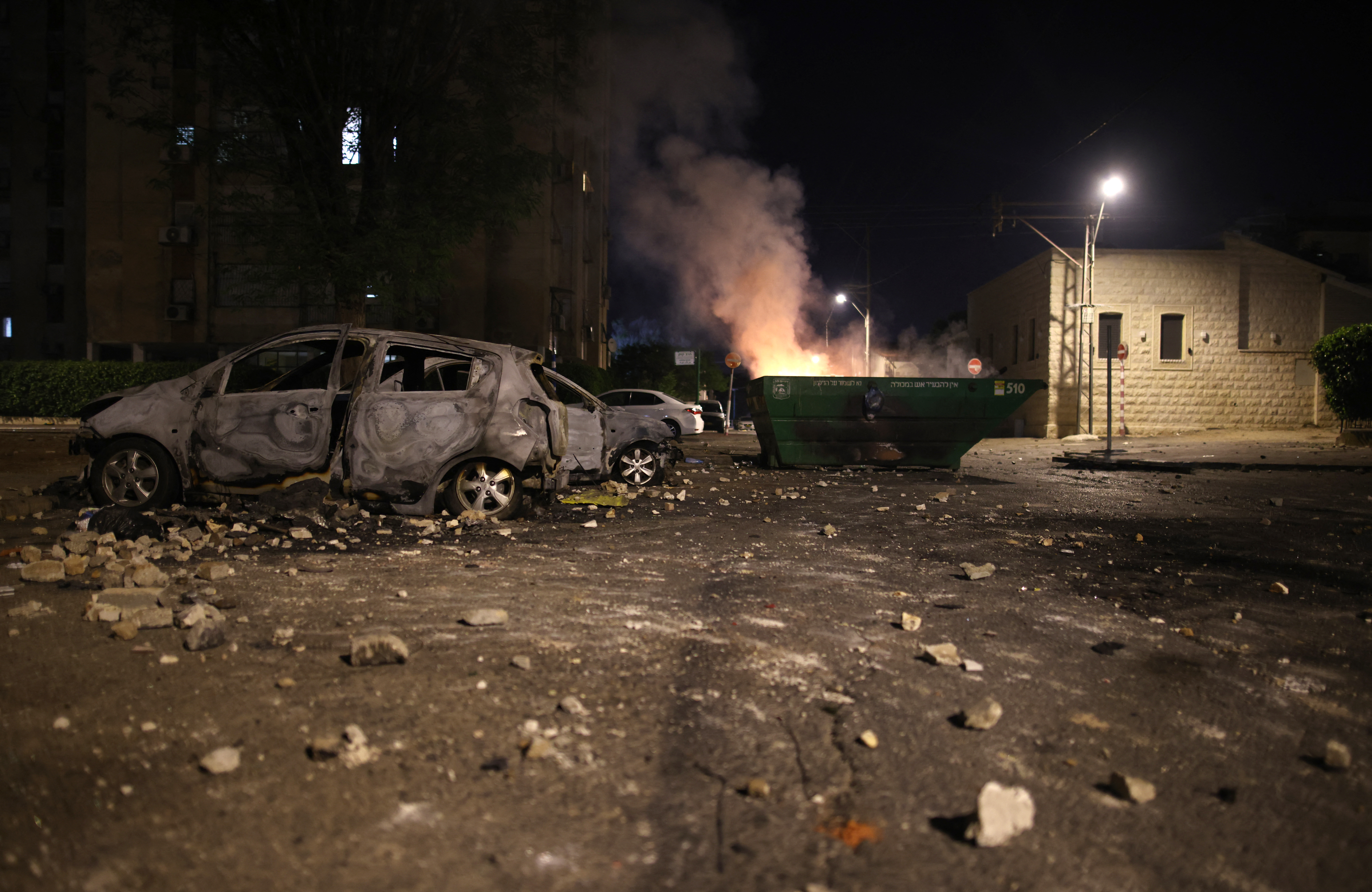 A picture shows burned cars and a rubbish container in the city of Lod on May 13