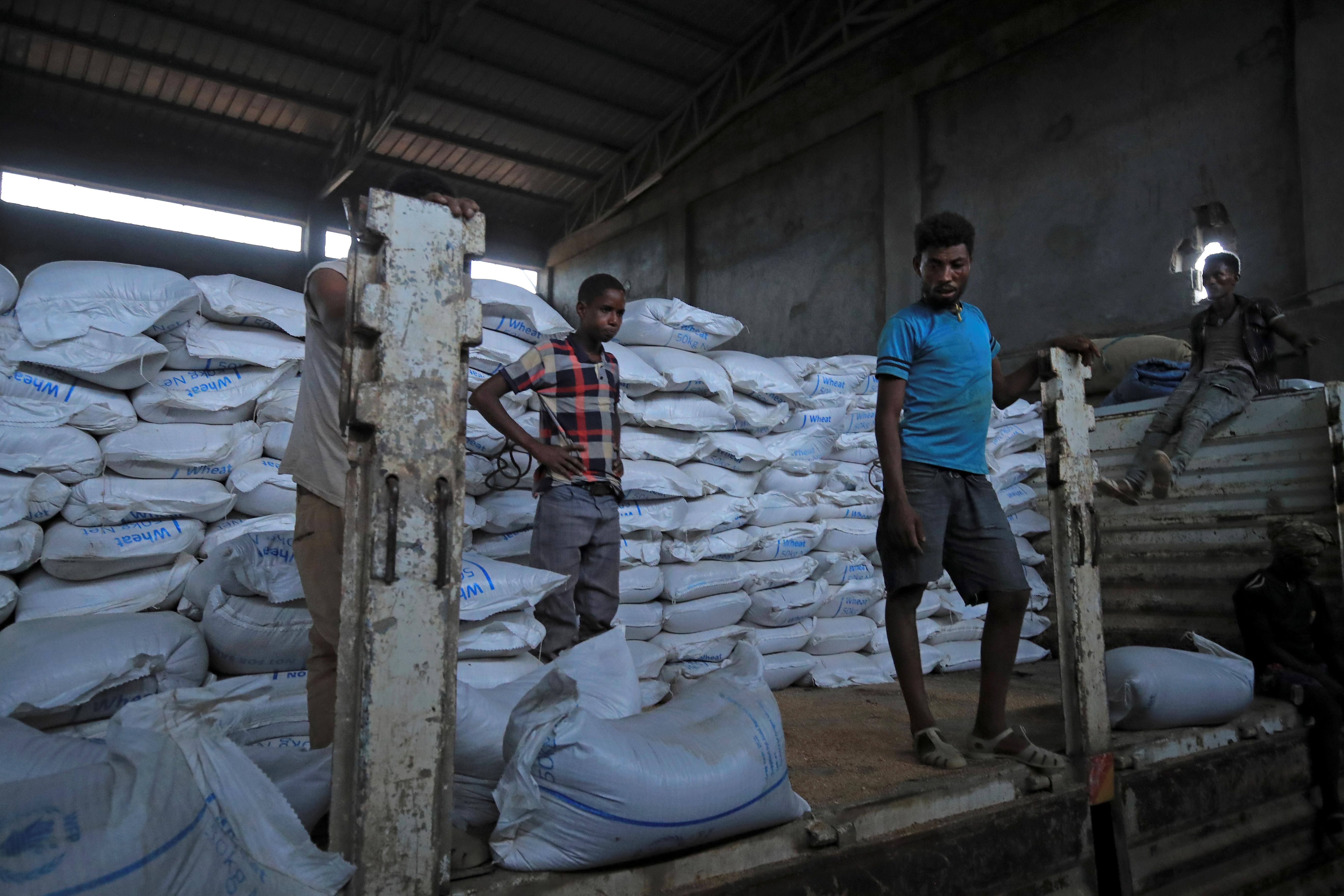 Ethiopian porters unload food aid bound for victims of war at a checkpoint leading to Tigray in Mai Tsebri town, Ethiopia on June 26, 2021. Ethiopia is one of the main beneficiaries of UK overseas aid [Stringer/Reuters]