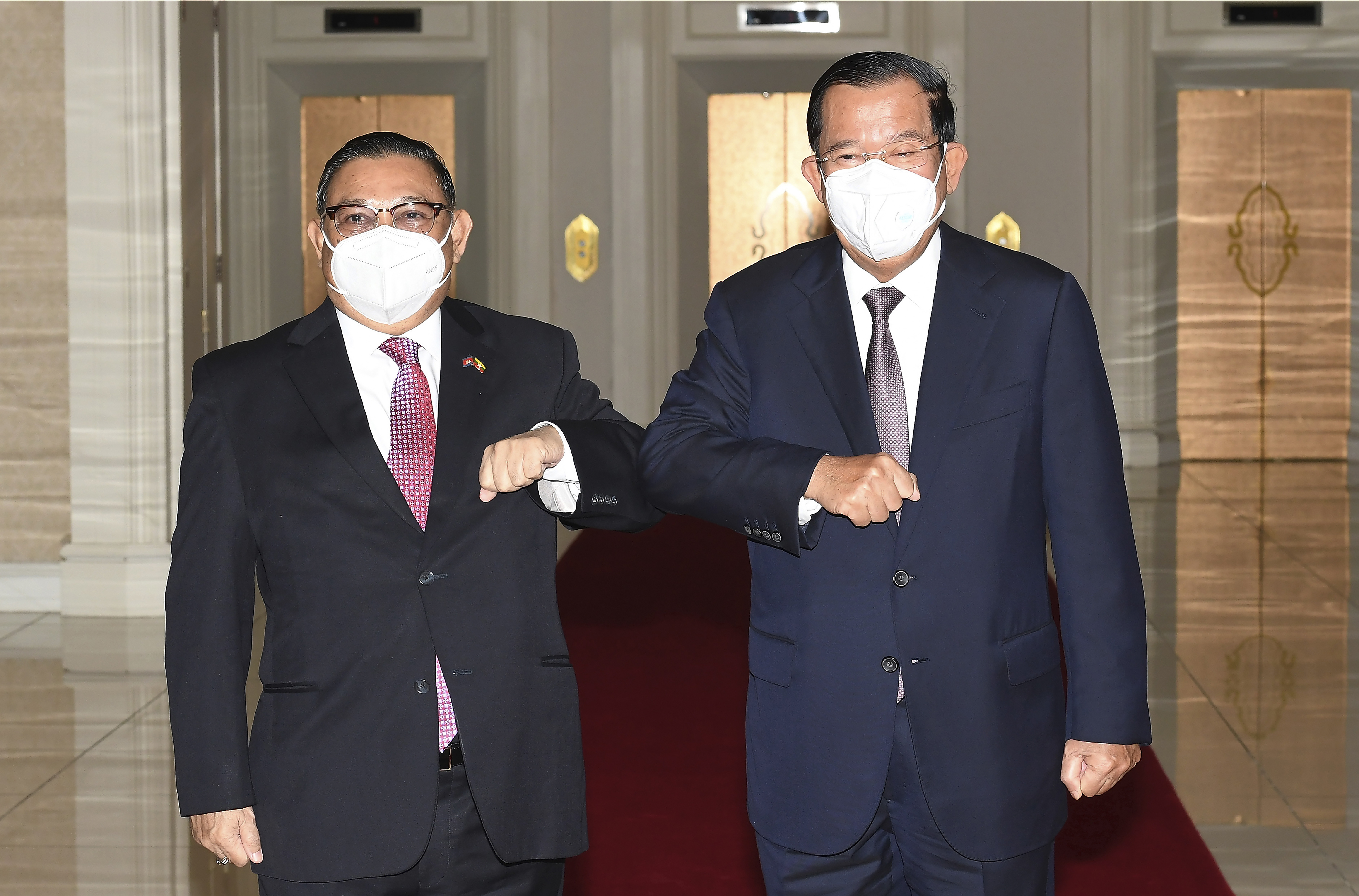 Cambodian Prime Minister Hun Sen, right, greets Myanmar's military-appointed Foreign Minister Wunna Maung Lwin at Peace Palace in Phnom Penh, Cambodia, December 7, 2021 [An Khoun SamAun/National Television of Cambodia via AP]