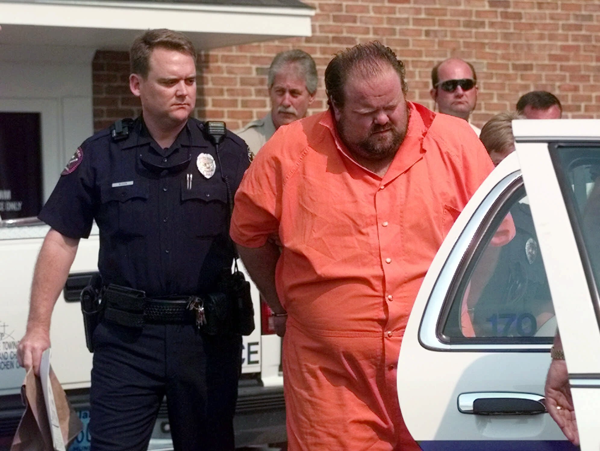 Officials escort murder suspect Alan Eugene Miller away from the Pelham City Jail in Ala., on August 5, 1999