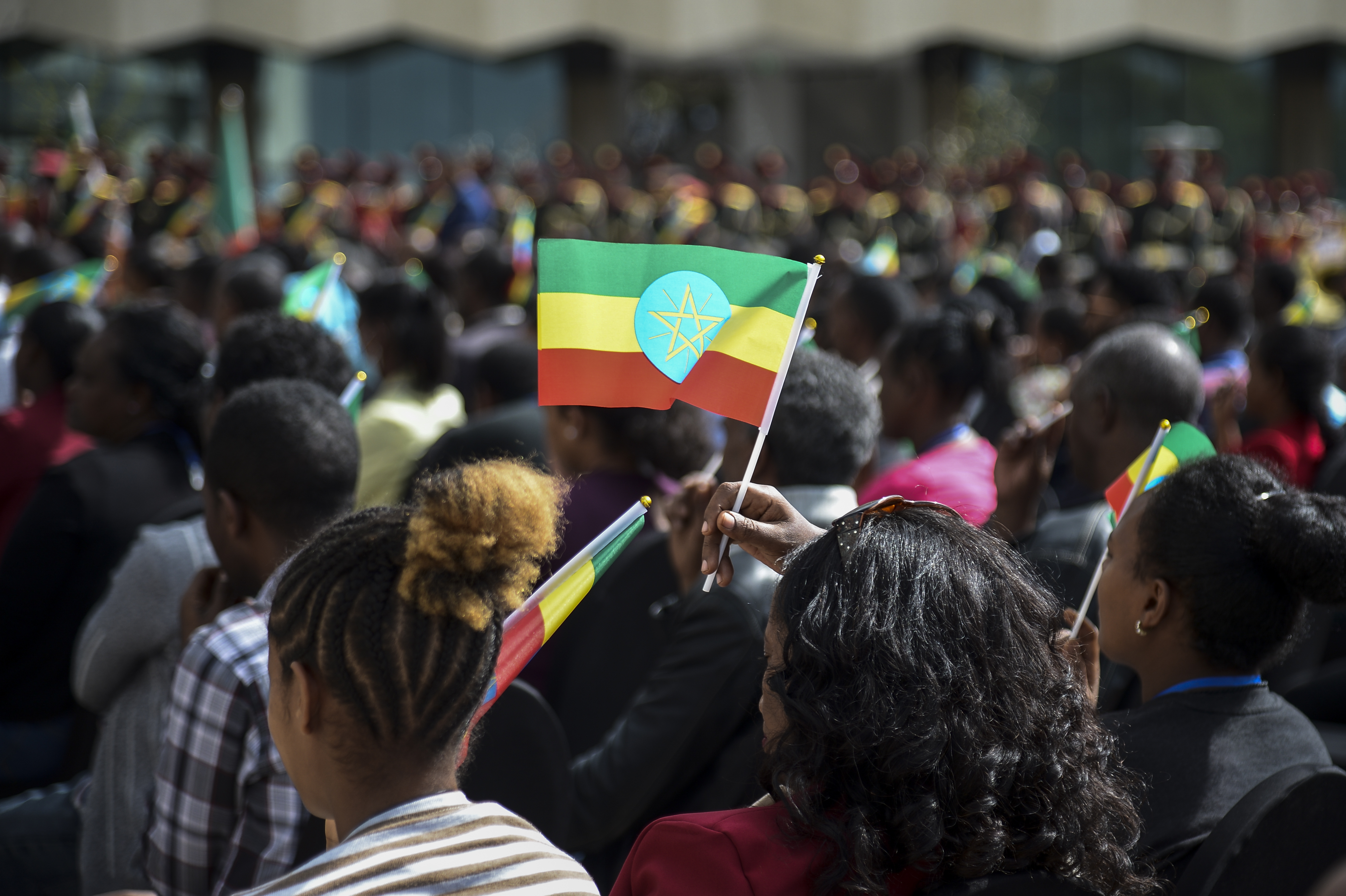 women holds Ethiopian flag at ceremony to remember fallen soldiers