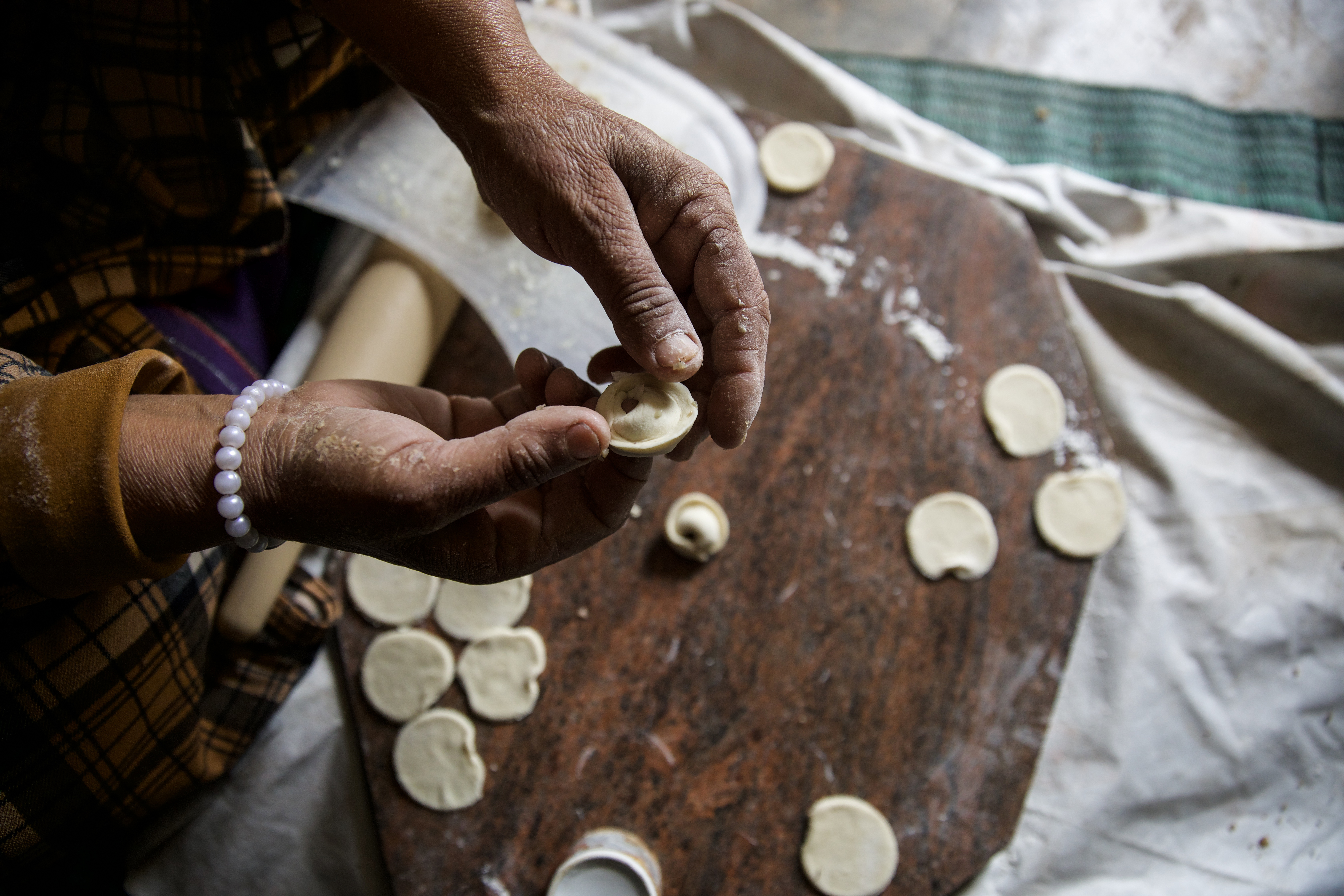 Fateem's hands work on small circles of dough