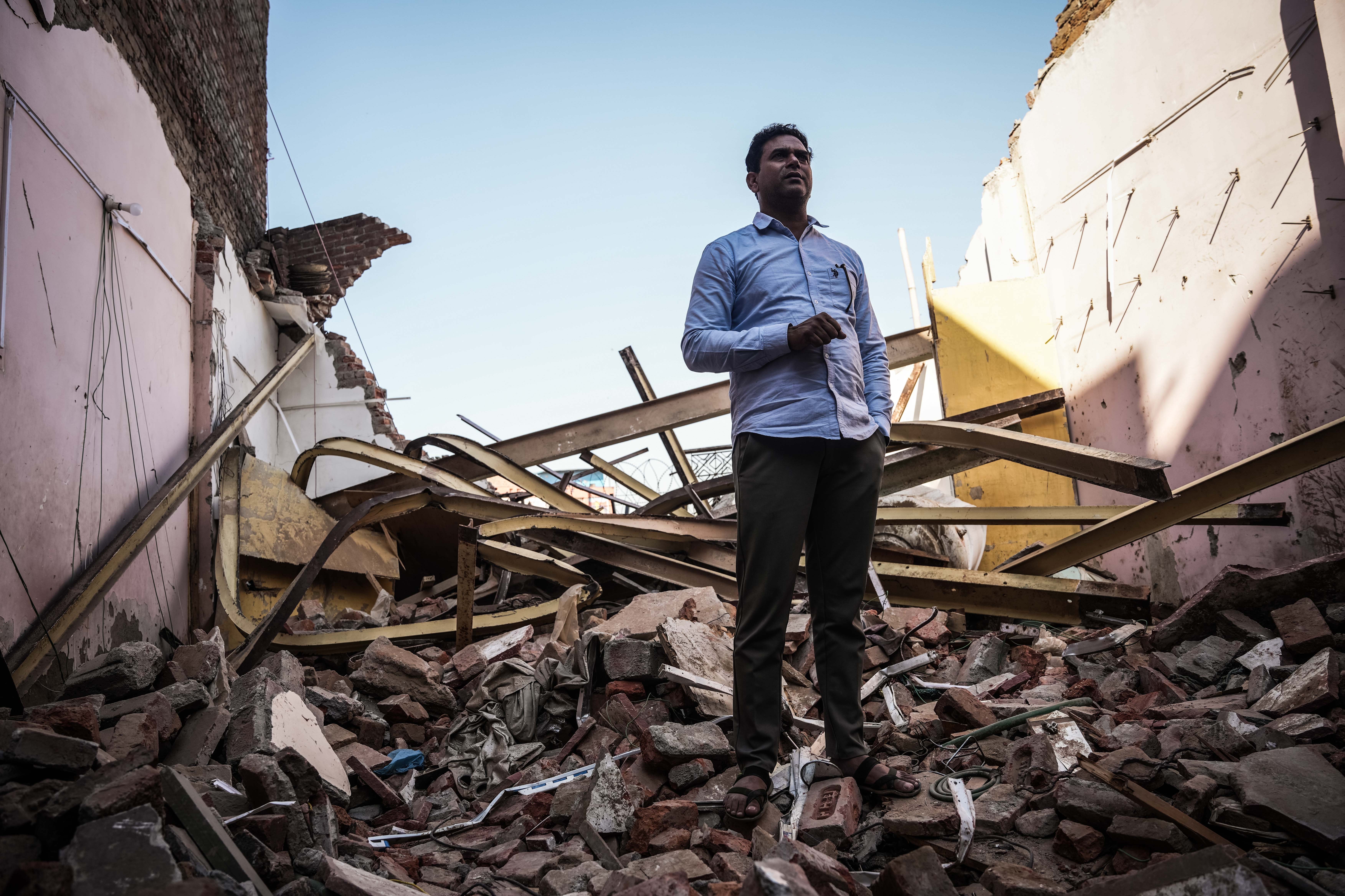 Wakeel Hasan, 45, a rat-hole miner who saved 41 trapped workers during a tunnel rescue, stands on a rubble-filled plot where his house was demolished by Indian authorities. [Md Meharban/Al Jazeera]