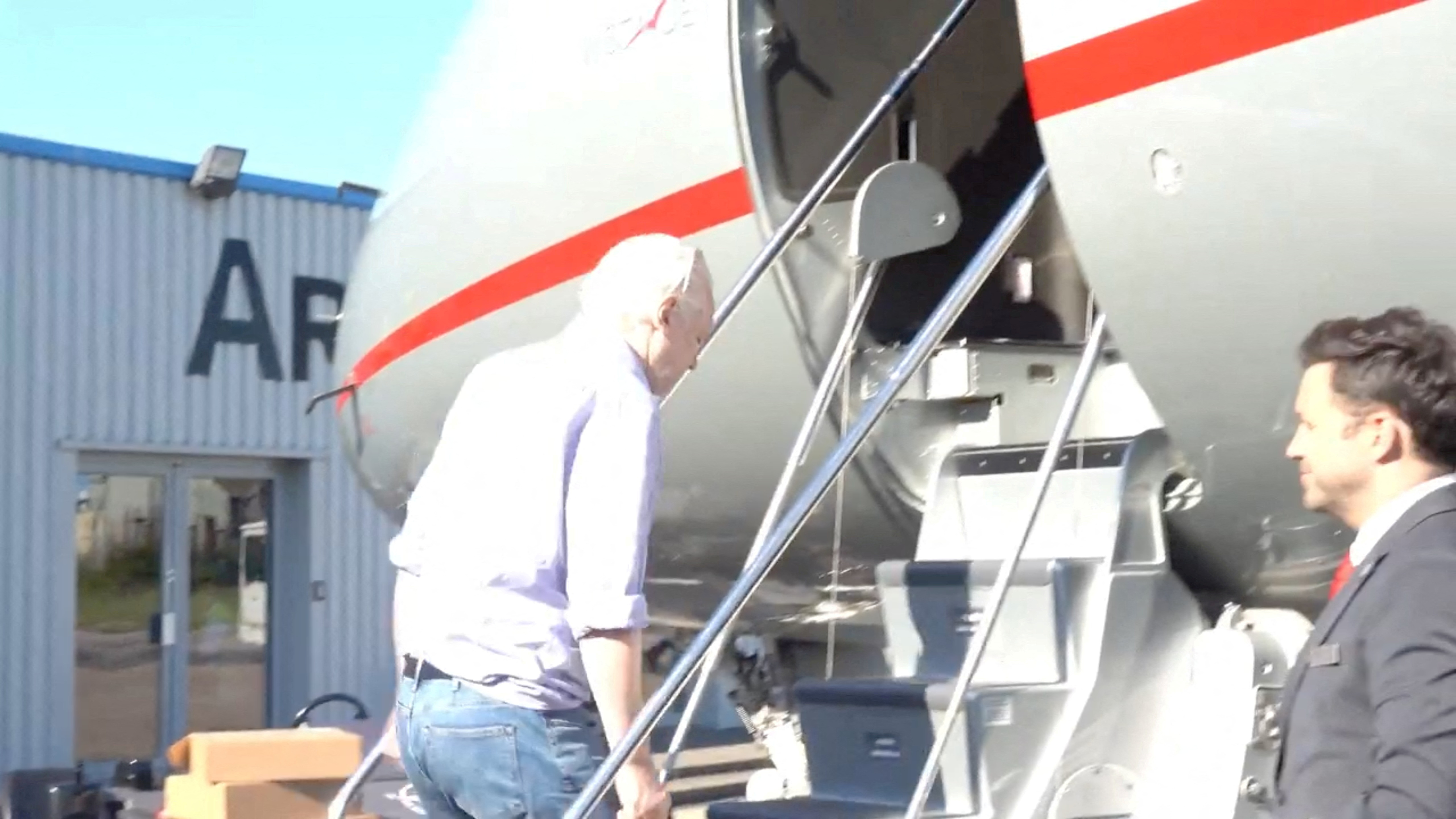 WikiLeaks founder Julian Assange boards a plane at a location given as London, UK