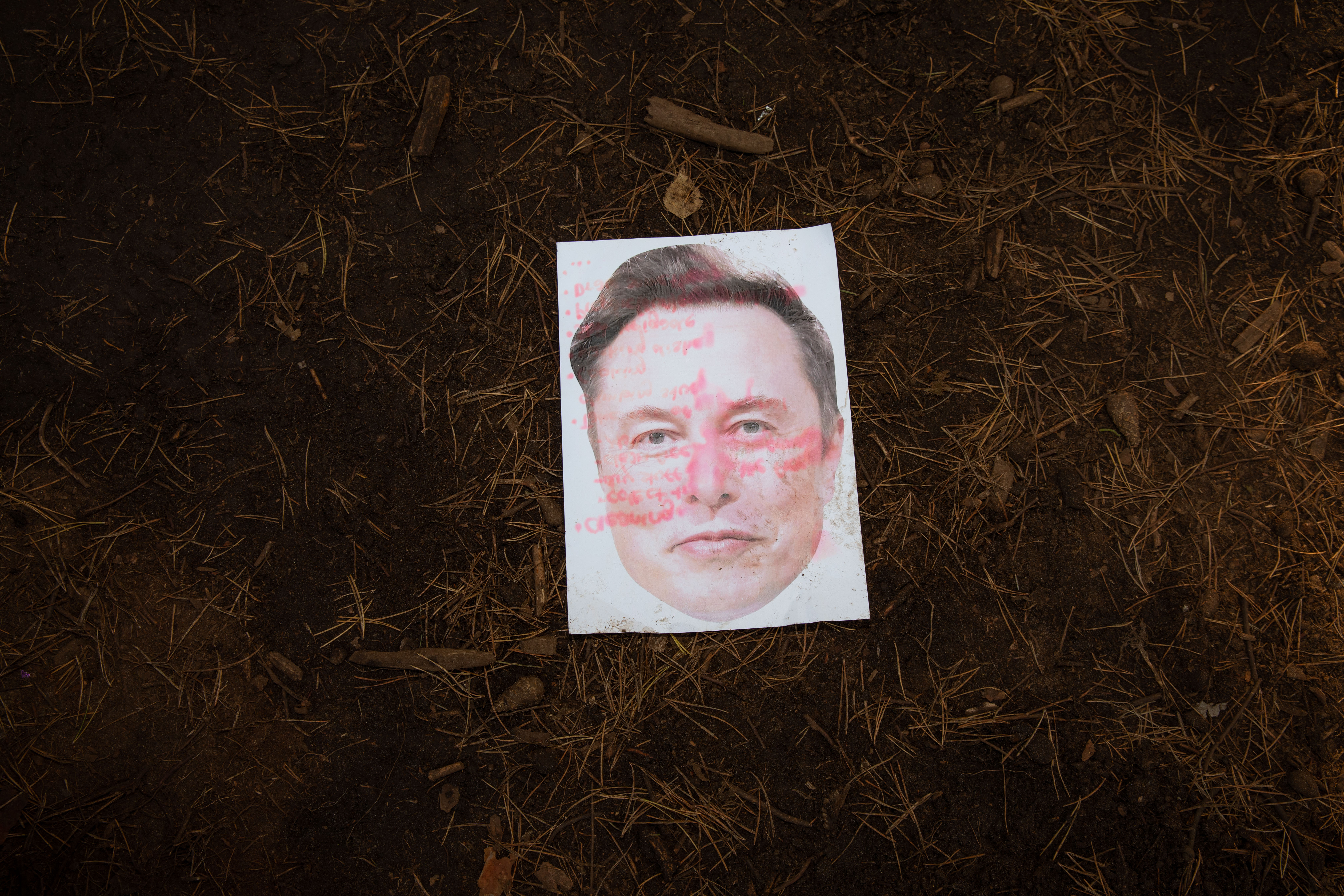 A photo of Elon Musk lies on the ground of the protest camp. The red writing on the photo is a to-do list written - and discarded - by one of the protesters