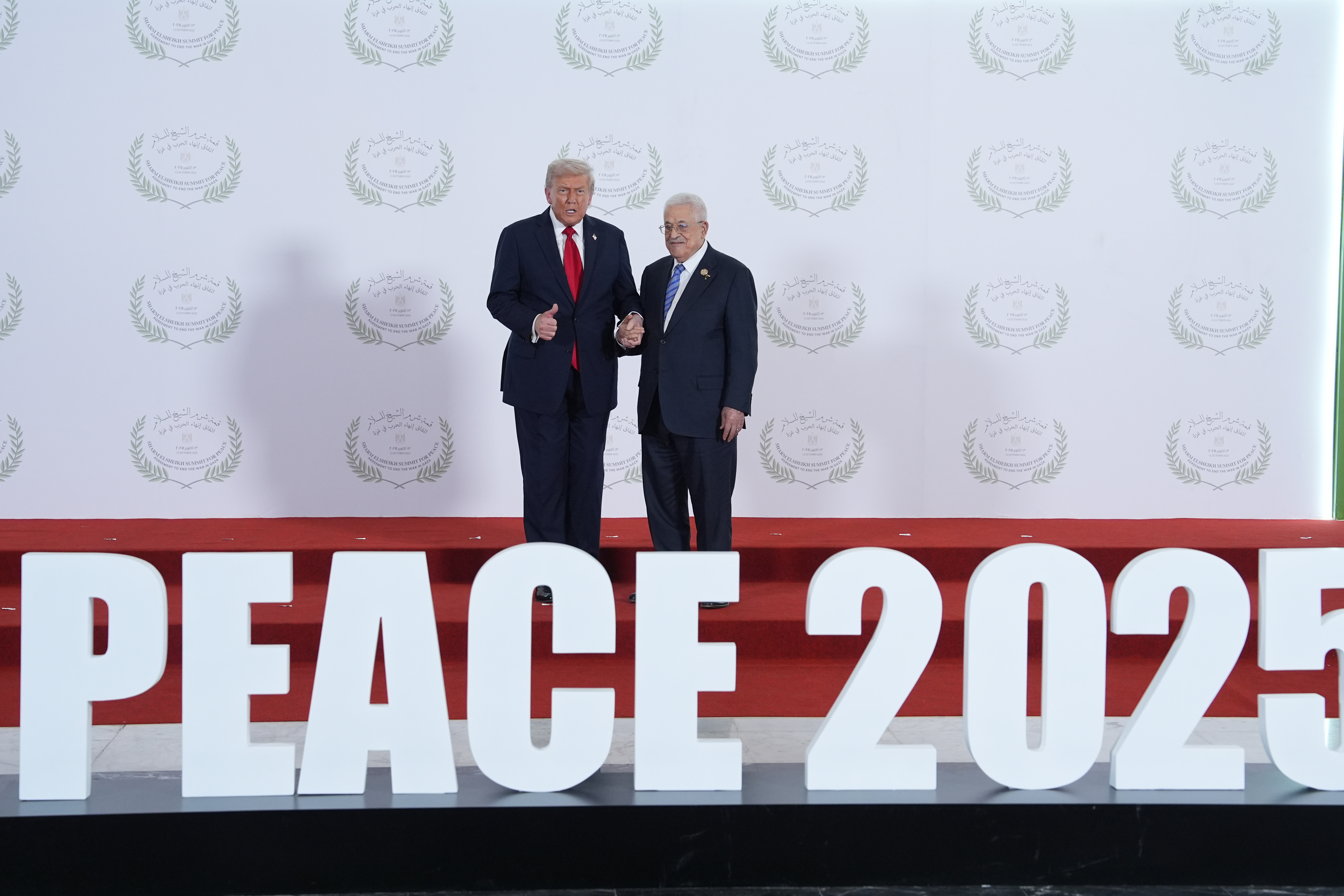 US President Donald Trump greets Palestinian President Mahmoud Abbas in Sharm El-Sheikh, Egypt