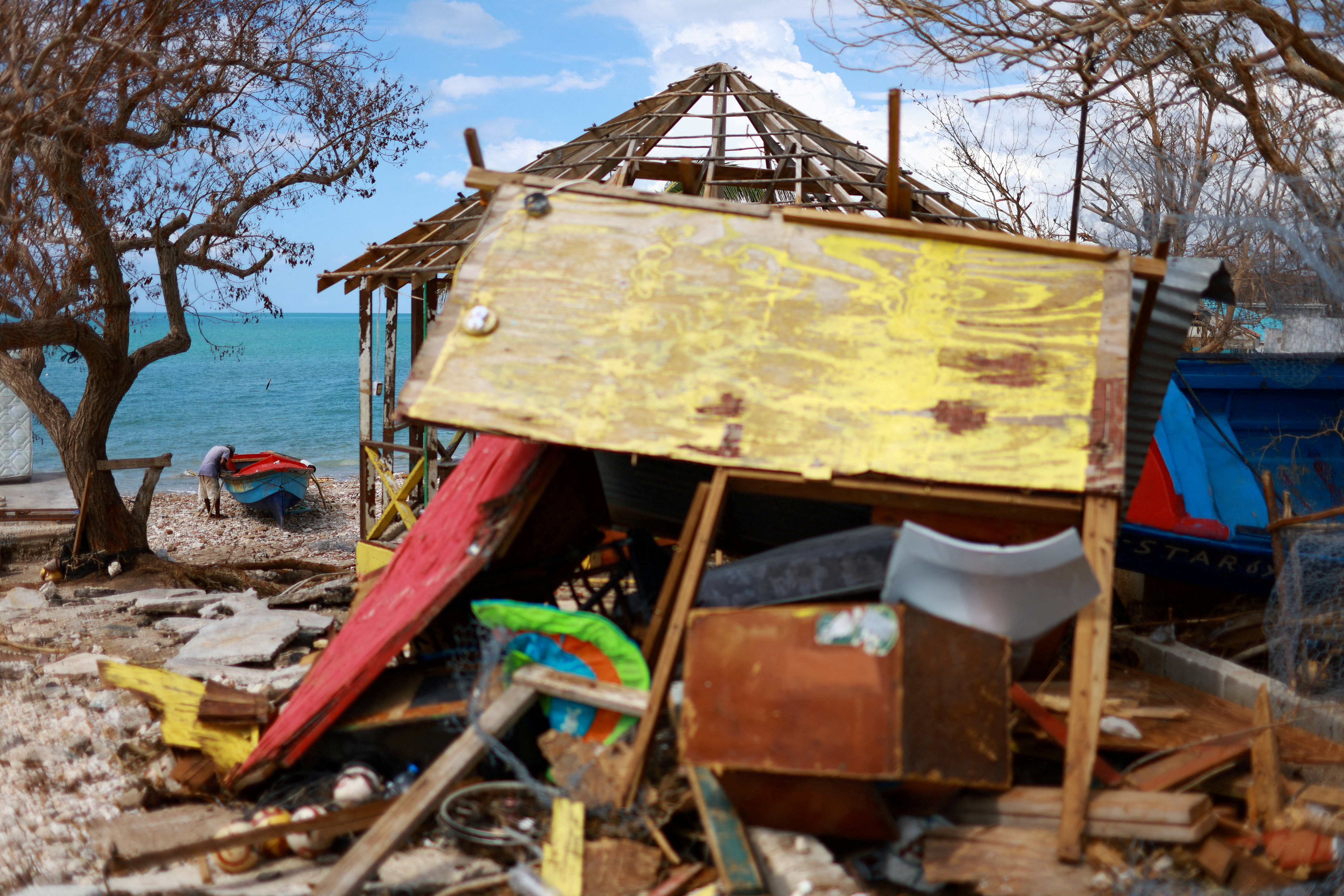 FILE PHOTO: A fisherman fixes his boat, damaged by Hurricane Melissa, on Treasure Beach, in St. Elizabeth, Jamaica, November 5, 2025. REUTERS/Raquel Cunha/File Photo