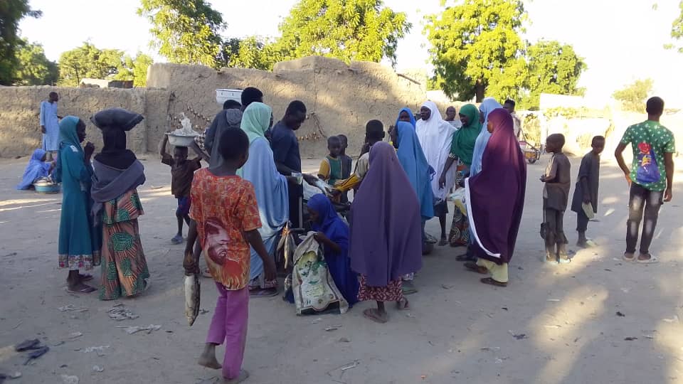 Residents of Malam Fatori buy fish at a local market in the town