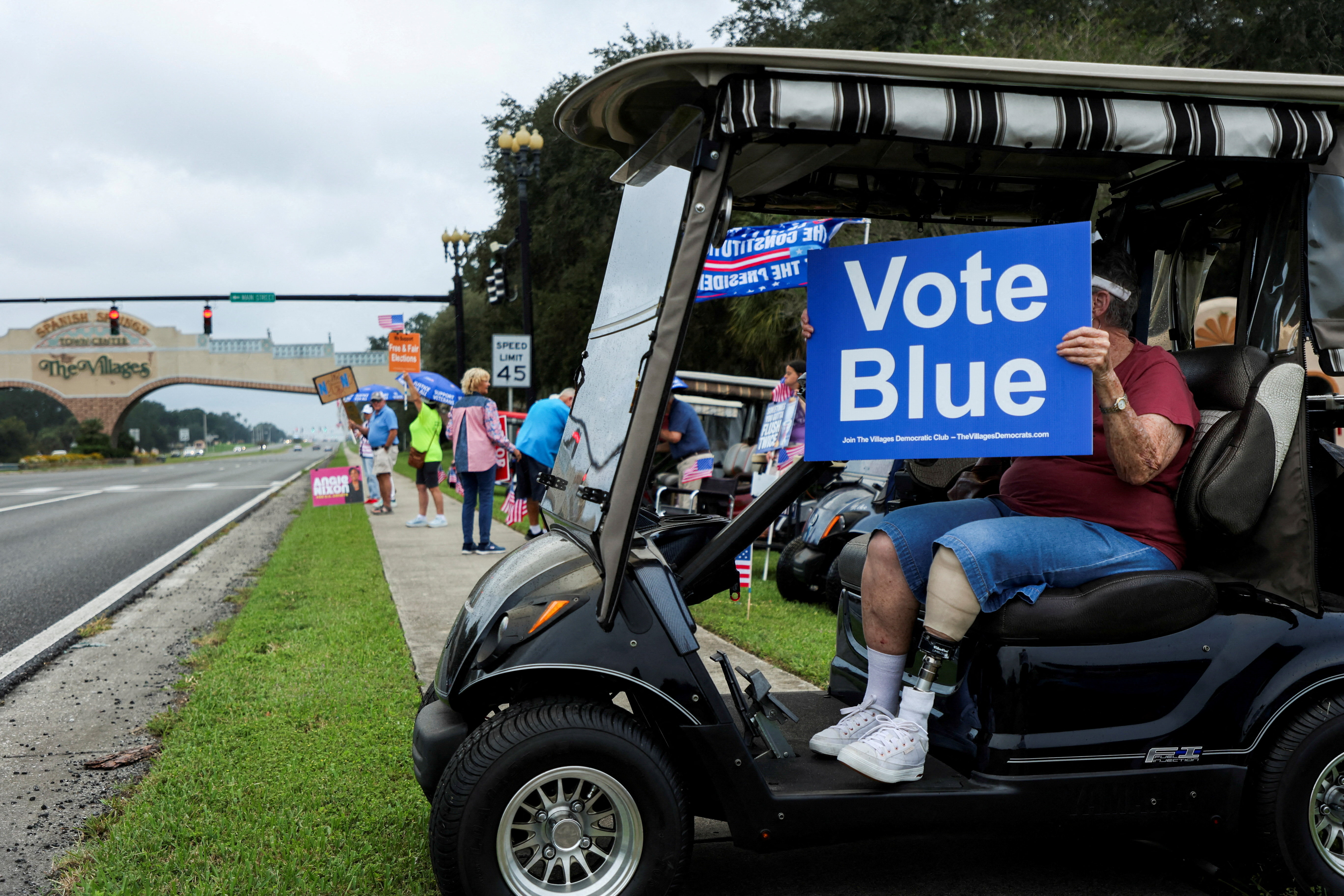 A man holds a "Vote Blue" sign while sitting in a golf cart during a Democratic rally in The Villages, Florida, US, October 17, 2026. REUTERS/Maria Alejandra Cardona TPX IMAGES OF THE DAY