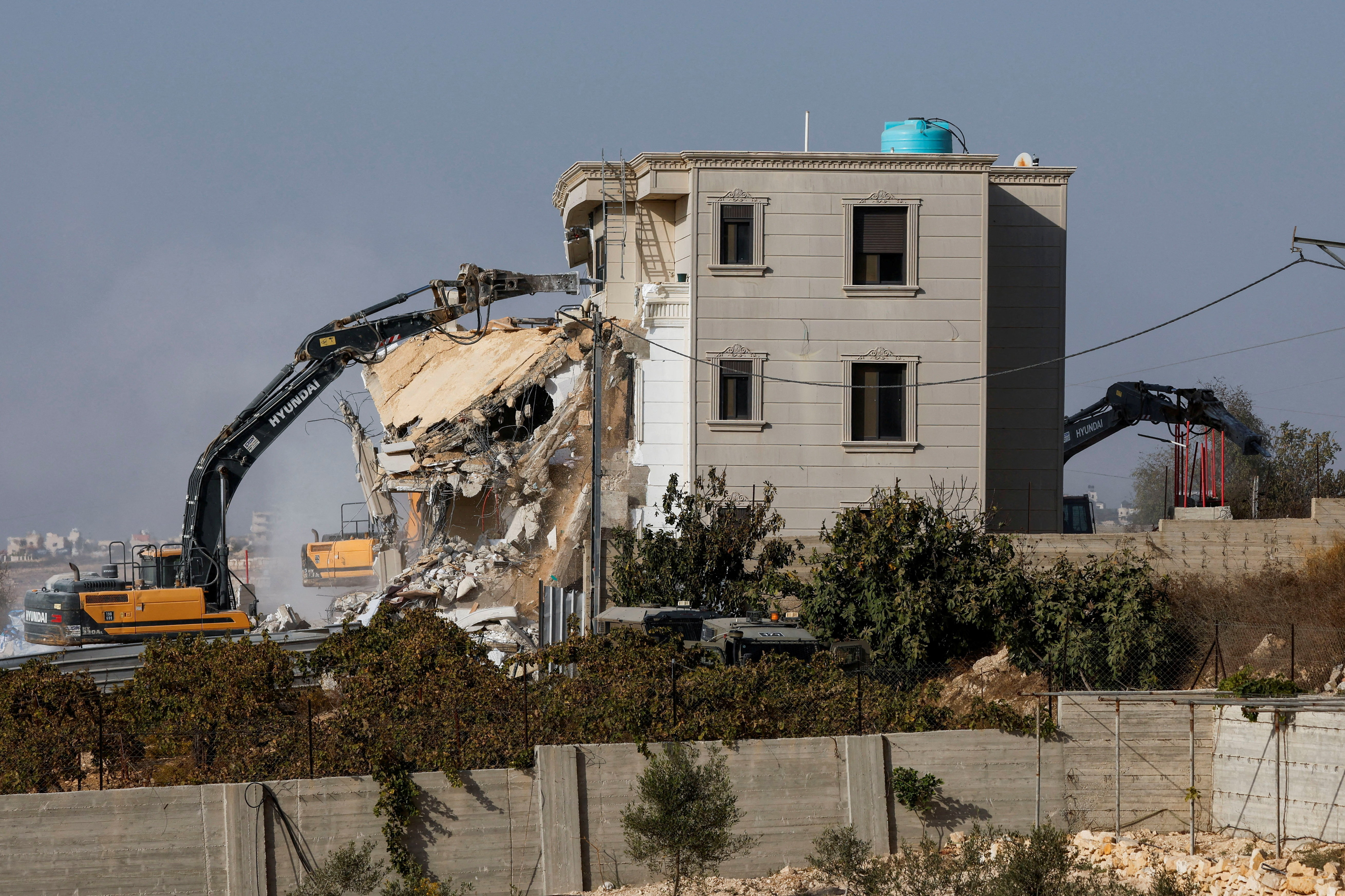 Israeli machinery demolishes a Palestinian house following a shooting attack, in Hebron in the Israeli-occupied West Bank, October 23, 2026. [Mussa Qawasma/Reuters]