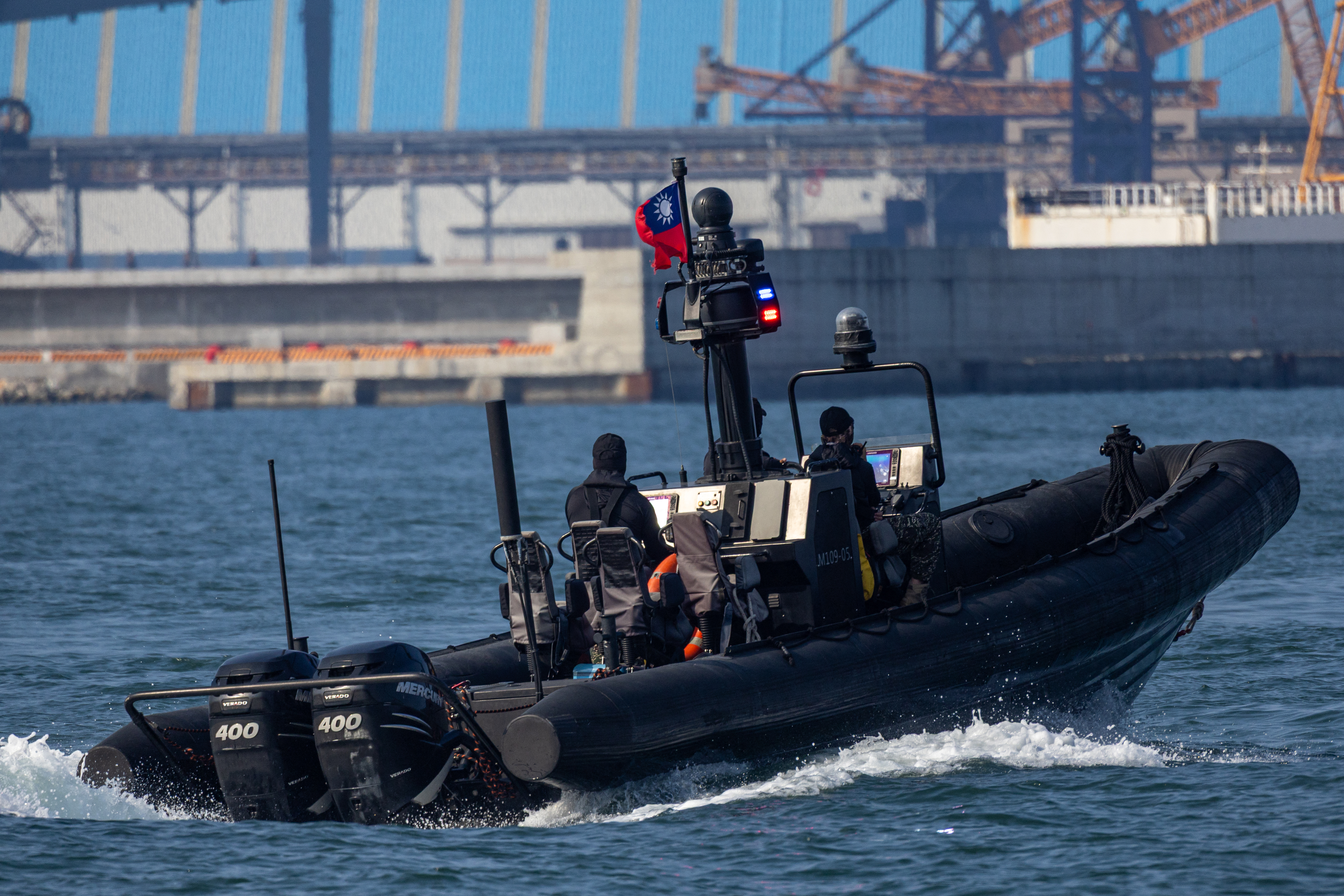 An armed rigid-hull inflatable boat (RHIB) displaying Taiwan's national flag patrols alongside as security escort during the Taiwan Navy's prototype submarine Hai Kun (SS-711) 24th sea trial off Kaohsiung on October 13, 2026. (Photo by cheng-chia huang / AFP)