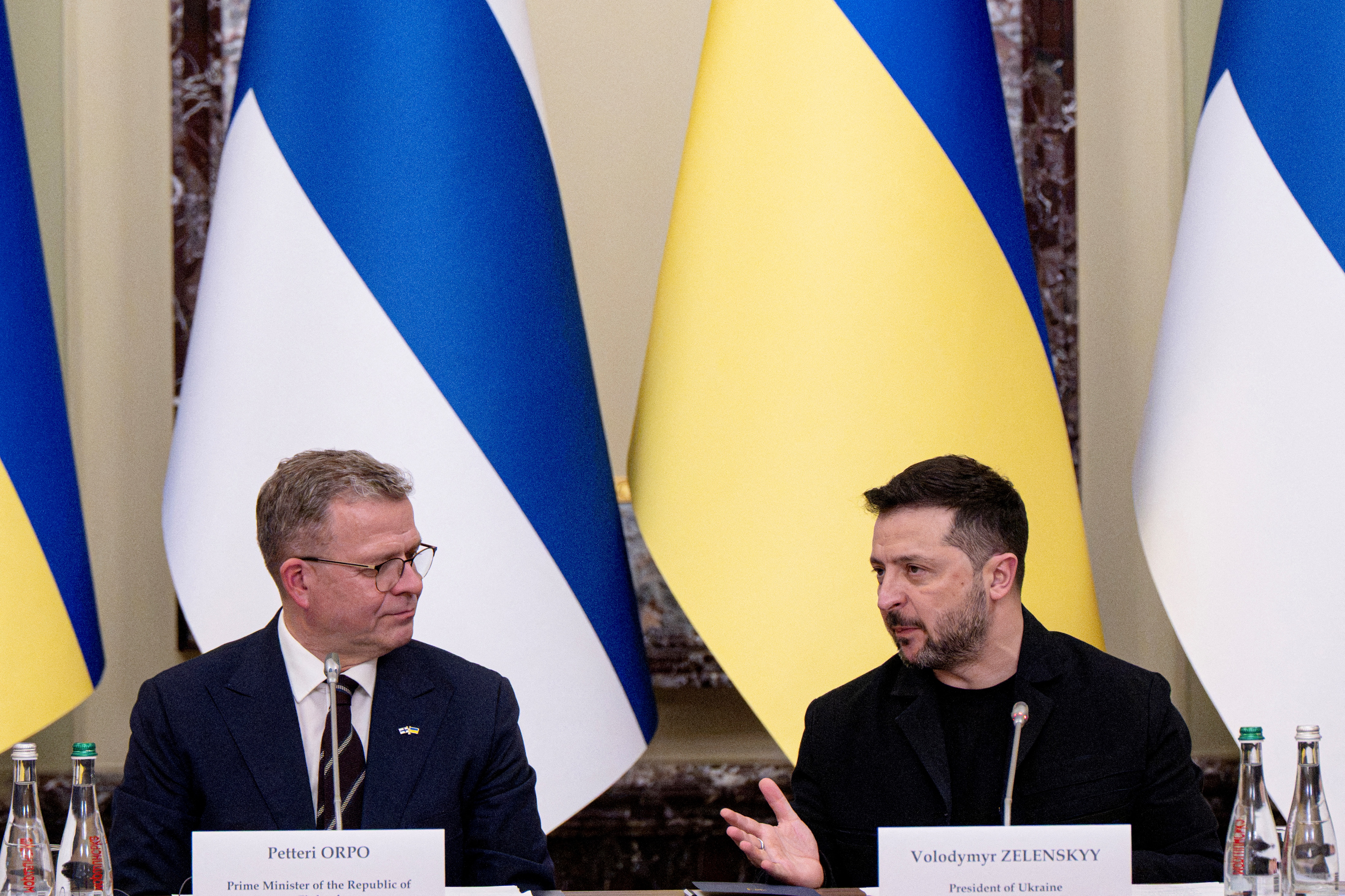 Ukraine's President Volodymyr Zelenskyy (R) and Finland's Prime Minister Petteri Orpo sit next to each other at a forum.
