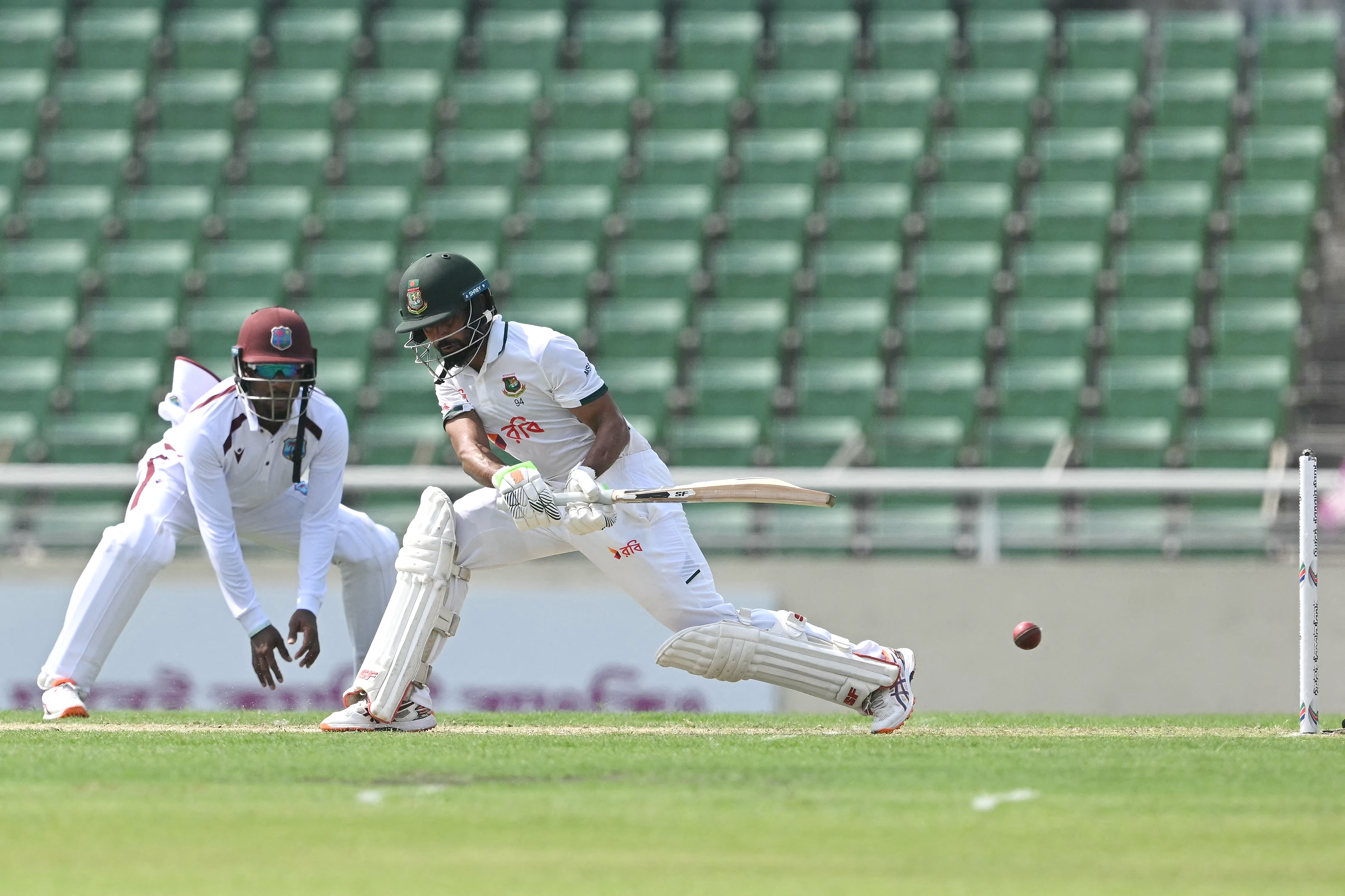 CORRECTION / Bangladesh's Shadman Islam (R) plays a shot as West Indies' wicketkeeper Amir Jangoo watches during the first day of the first test cricket match between Bangladesh and West Indies at the Sher-e-Bangla National Stadium in Mirpur on October 28, 2026.