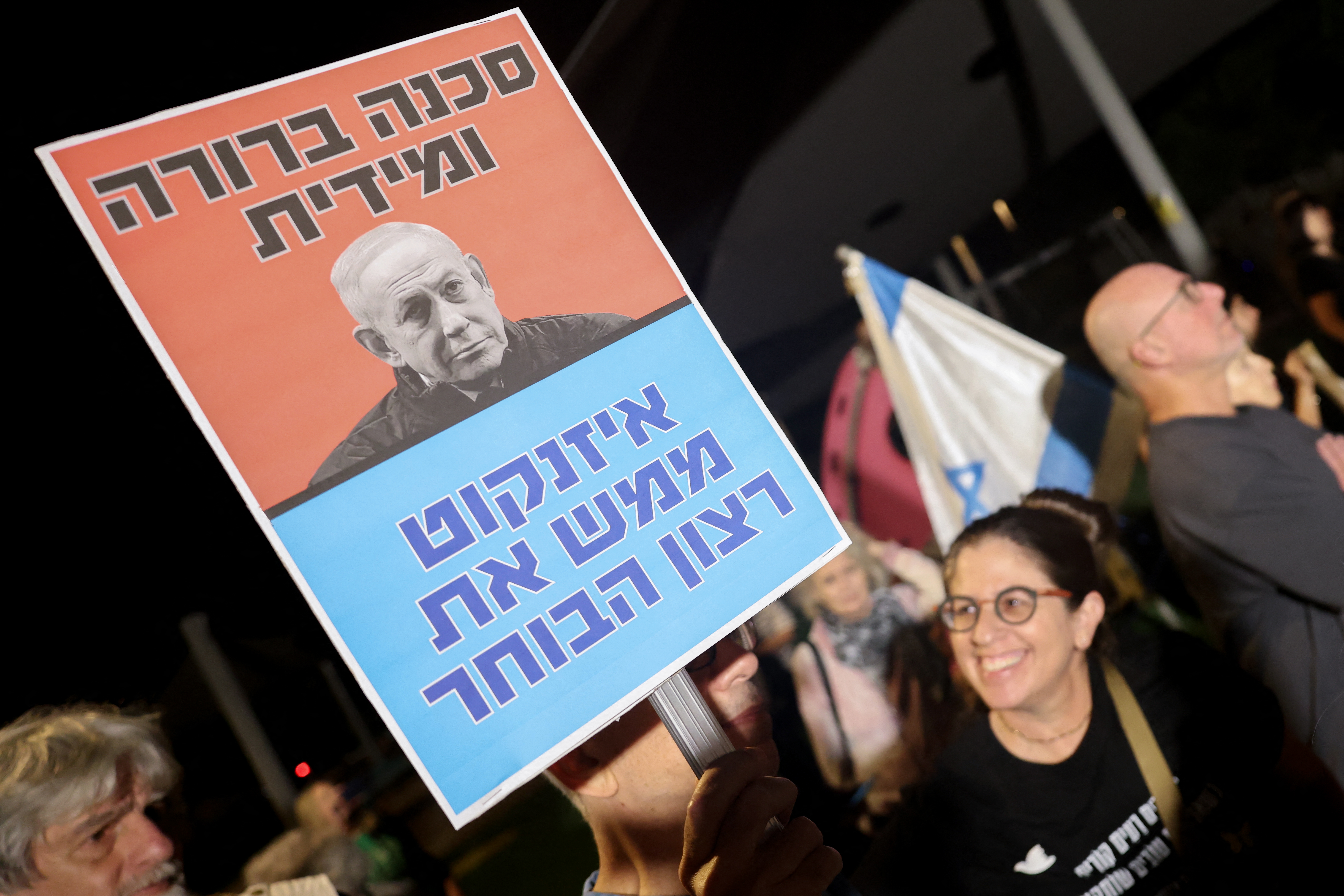 Israeli left-wing activists hold placards during a demonstration outside the home of Gadi Eisenkot, leader of the Yashar party, in Herzliya on October 29, 2026, calling for the formation of a government that includes Arab parties.